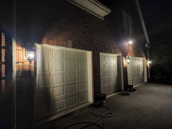 Professional outdoor lighting installation on garage doors and facade